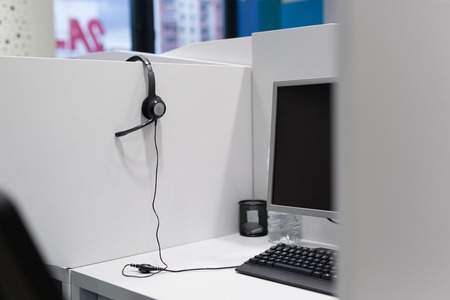 Computer and headset in empty call center officeの写真素材