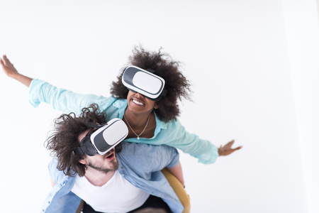 Happy multiethnic couple getting experience using VR headset glasses of virtual reality, isolated on white backgroundの写真素材