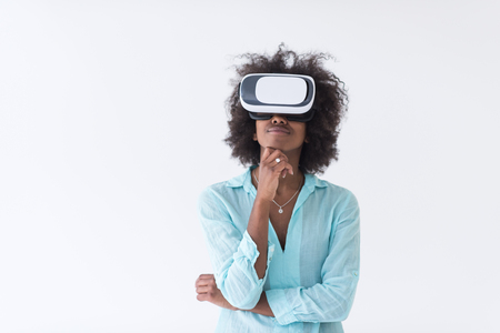 Happy african american girl getting experience using VR headset glasses of virtual reality, isolated on white backgroundの写真素材