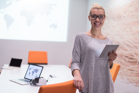 young female entrepreneur working on digital tablet in night office