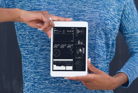 Young Happy African American Woman Using Digital Tablet  Isolated on a gray backgroundの写真素材