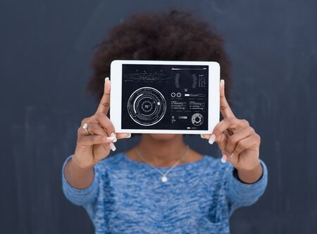 Young Happy African American Woman Using Digital Tablet  Isolated on a gray backgroundの写真素材