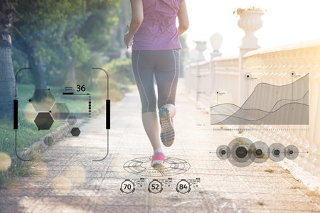 Fitness woman training and jogging in summer park, close up on running legsの写真素材