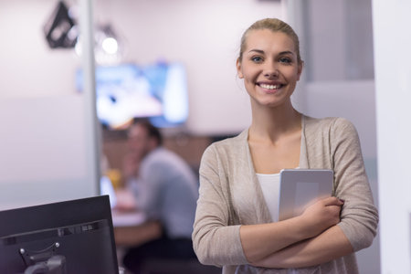 Pretty Businesswoman Using Tablet In front of startup Office Interior