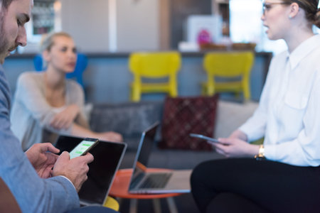 Young casual businessman using smartphone in the startup office