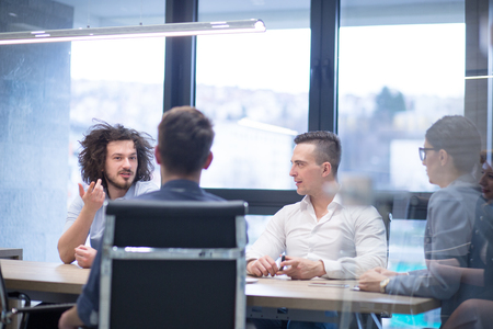 Group of a young business people discussing business plan at modern startup office buildingの写真素材