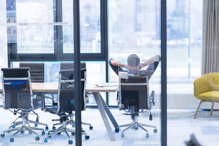 A time for relax. Young tired casual businessman relaxing at the desk in his officeの写真素材