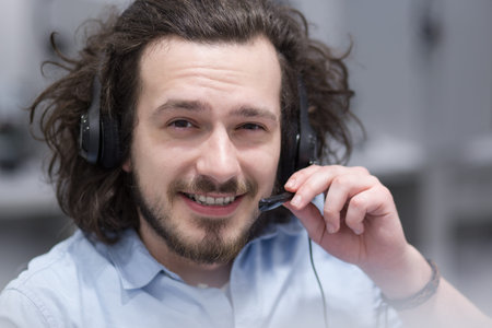 young smiling male call centre operator doing his job with a headset