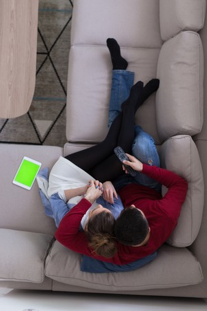 top view of Young couple on the sofa watching television together at homeの写真素材