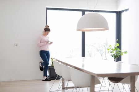 beautiful young woman using tablet computer on the floor at homeの写真素材