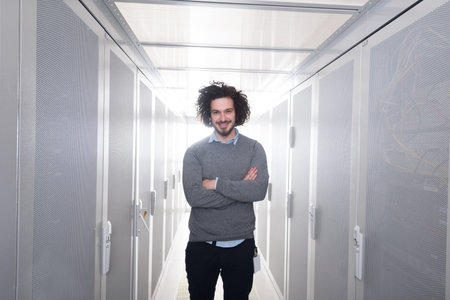 portrait of young handsome IT engeneer in datacenter server room