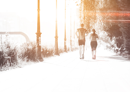 urban sports, healthy young couple jogging  in the city at sunny morningの写真素材