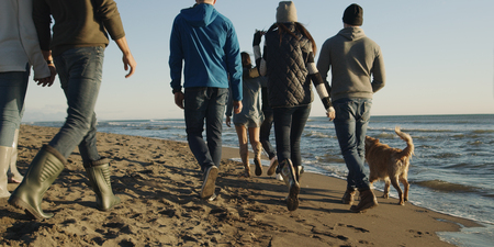 Group Of Young Friends Spending The Day On A Beach during autumn dayの写真素材