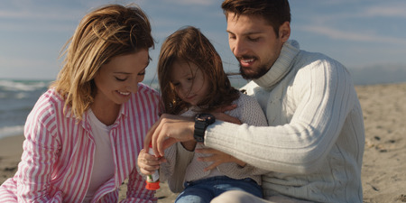 Family with kids resting and having fun at beach during autumn dayの写真素材