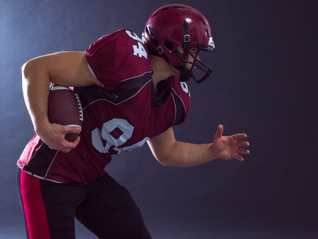 American football Player running with the ball isolated on a gray backgroundの写真素材