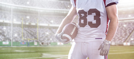 Closeup Portrait of a strong muscular American Football Player on big modern stadium field with...