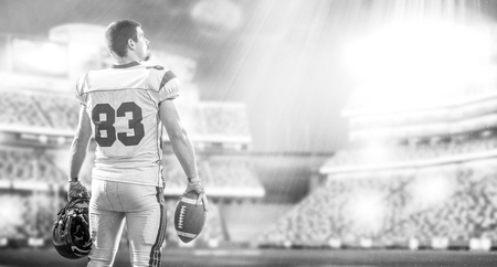American Football Player isolated on big modern stadium field with lights and flaresの写真素材