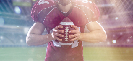 Closeup Portrait of a strong muscular American Football Player on big modern stadium field with lights and flaresの写真素材