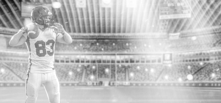 one quarterback american football player throwing ball isolated on big modern stadium field with lights and flaresの写真素材