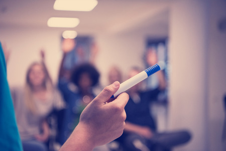 close up of teacher hand with marker while teaching lessons in school classroom to multiethnic studentsの写真素材