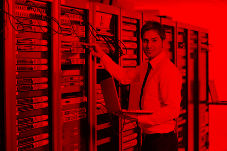 young engeneer business man with thin modern aluminium laptop in network server roomの写真素材