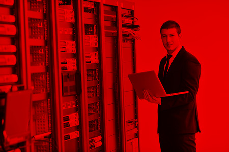 young engeneer business man with thin modern aluminium laptop in network server roomの写真素材