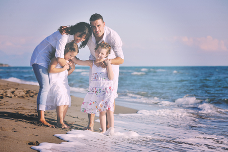 happy young family in white clothing have fun at vacations on beautiful beach の写真素材