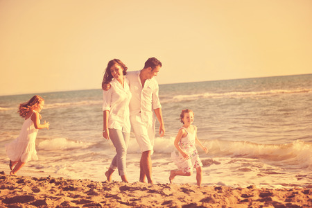 happy young family in white clothing have fun at vacations on beautiful beach の写真素材