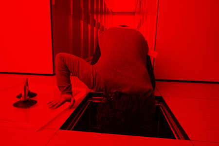 young IT engineer connecting cables in server room at modern data centerの写真素材