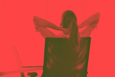 portrait of Young pretty business woman work on  notebook computer  in the bright modern office indoorsduo toneの写真素材