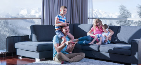 Happy family. Father, mother and children playing a video game Father and son playing video games together on the floorの写真素材