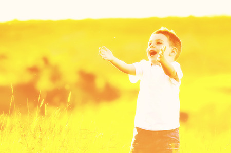 happy young beautiful child have fun on eadow with soap bubbles toyの写真素材