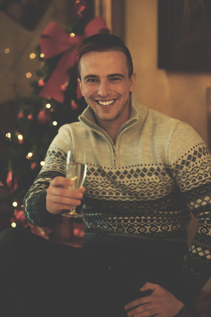 portrait of young man with champagne glass  on party celebrate christmas and new year at homeの写真素材