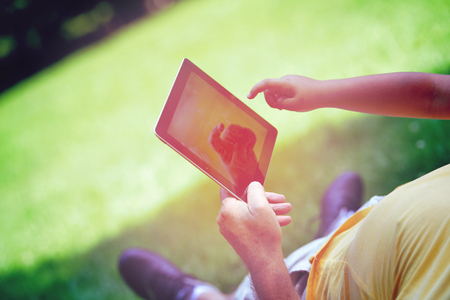 grandfather and child in park using tablet computerの写真素材