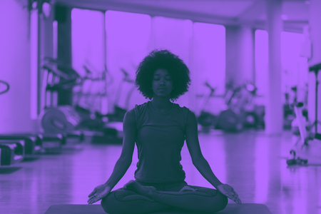 beautiful young african american woman exercise yoga in gym duo tone filterの写真素材