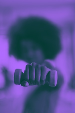 happy healthy african american woman working out in a crossfit gym on weight loss with dumbbells duo tone filterの写真素材