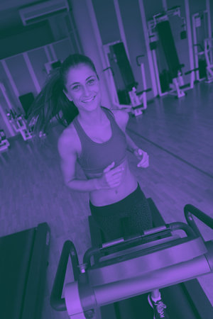 sport, fitness, lifestyle, technology and people concept - smiling woman exercising on treadmill in...