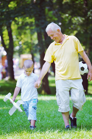 happy grandfather and child have fun and play in parkの写真素材