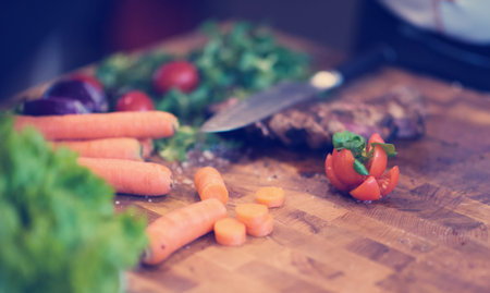 Juicy slices of grilled steak  with vegetables on a wooden board
