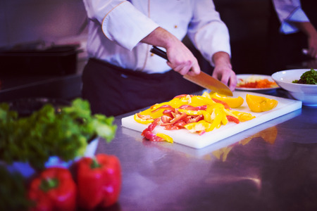 Chef cutting fresh and delicious vegetables for cooking or saladの写真素材