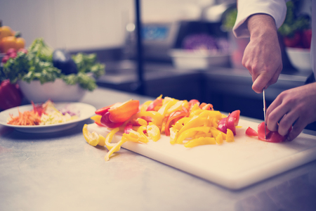 Chef cutting fresh and delicious vegetables for cooking or saladの写真素材
