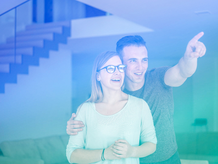 Portrait of a happy young beautiful couple hugging in their new homeの写真素材