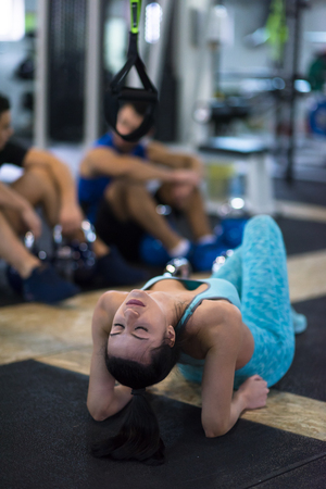 young athlete woman lying on the floor and relaxing before a hard training at cross fitness gymの写真素材