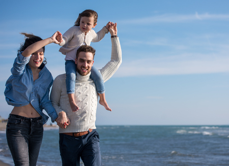 Family with kids resting and having fun at beach during autumn dayの写真素材