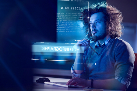 Young man working on computer at night in dark office. The designer works in the later time.の写真素材