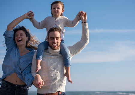 Family with kids resting and having fun at beach during autumn dayの写真素材