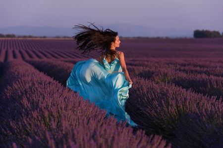 lavander flower field woman in cyand dress having fun and relax on wind in  purple flower fieldの写真素材