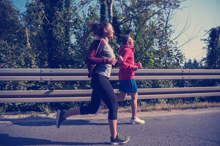 young couple enjoying in a healthy lifestyle while jogging along a country road, exercise and fitness conceptの写真素材