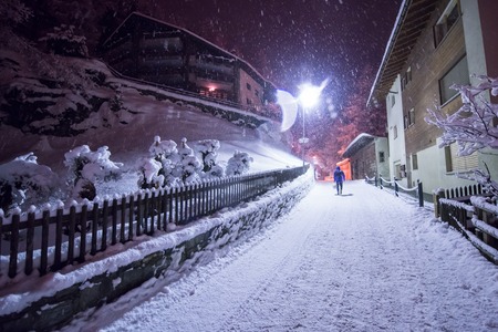 a view on snowy streets of the Alpine mountain village in the cold winter nightの写真素材