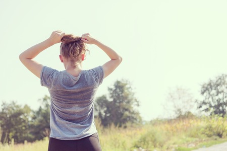 young woman enjoying in a healthy lifestyle while jogging along a country road, exercise and fitness conceptの写真素材